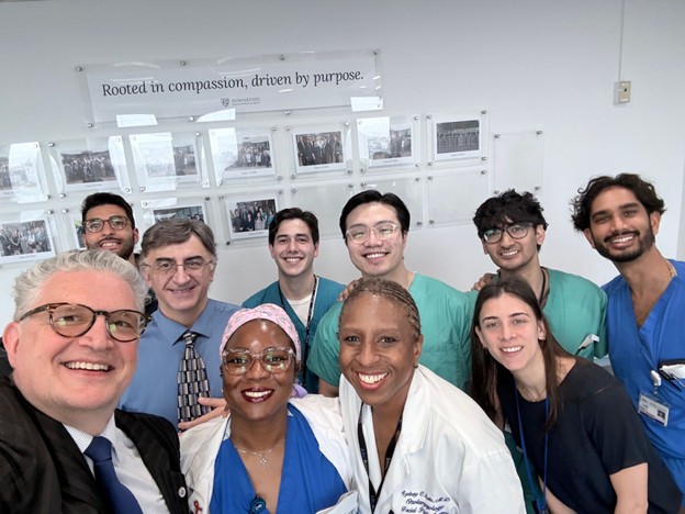 a group of doctors, staff and nurses smiling for a group photo