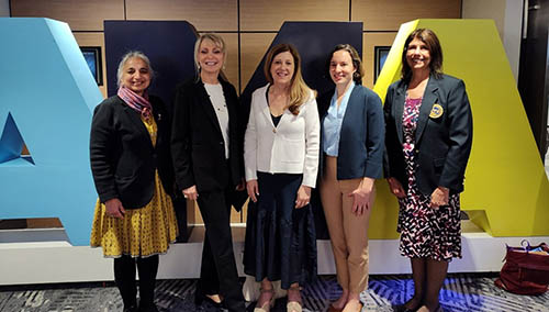 women posing for a photo in front of large AMA letters